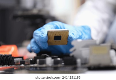Engineer holds in hands powerful processor or board after repair. CPU on computer motherboard concept