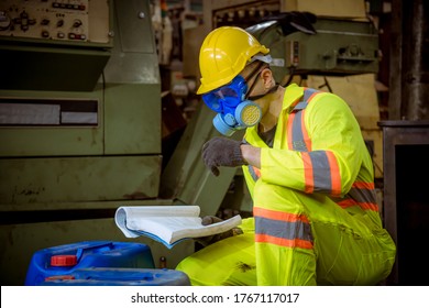 A Engineer Industry Wearing Safety Uniform ,black Gloves ,gas Mask Under Reading Document Detail And Checking Chemical Tank In Industry Factory Work.