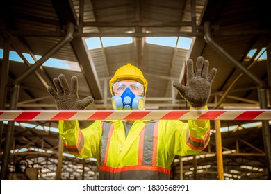 Engineer industry wearing safety uniform ,black gloves and gas mask show hand signal no entry chemical dangerous area in industry factory work.