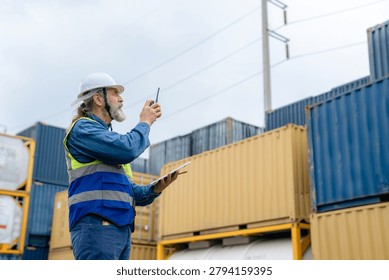Engineer inspecting cargo containers at warehouse yard. Shipping, freight transport.