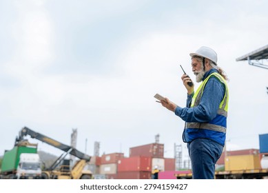 Engineer inspecting cargo containers at warehouse yard. Shipping, freight transport.