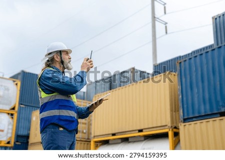 Engineer inspecting cargo containers at warehouse yard. Shipping, freight transport.
