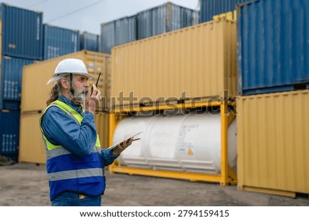 Engineer inspecting cargo containers at warehouse yard. Shipping, freight transport.