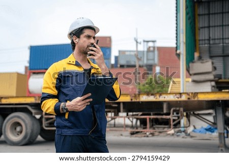 Engineer inspecting cargo containers at warehouse yard. Shipping, freight transport.