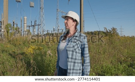 An engineer is inspecting electrical equipment while working outdoors in a professional capacity