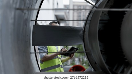 Engineer inspecting internal structure of large industrial fan on site