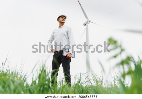 Engineer inspecting Project Manager at the\
Wind Farm. Man working in the\
enviromental