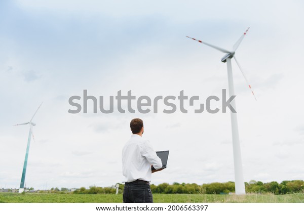 Engineer inspecting Project Manager at the\
Wind Farm. Man working in the\
enviromental