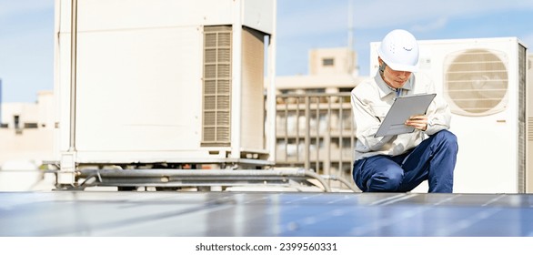 Engineer inspecting solar panels on the roof of a building