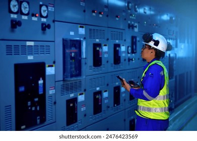 Engineer inspection electrical current and checking status switch gear electrical energy distribution substatio, routine checking, low light.