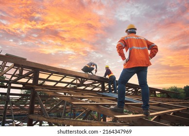Engineer inspects, installers, repairs roofs above the clouds, blue sky, technicians install roofing at the top of the house, renovate, renovate, build a country house - Shutterstock ID 2164347969