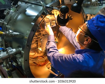 Engineer Installing The Monochromator For X-ray Energy Selection In Synchrotron Light Source Laboratory.