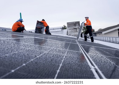 Engineer installing solar panels on wet metal rooftop during cloudy weather, highlighting renewable energy development in a tropical urban area.