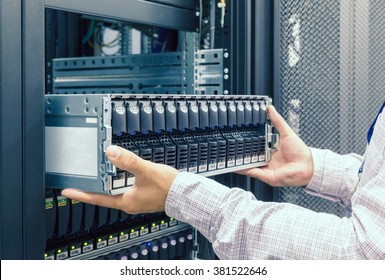 IT Engineer Installs Enclosure With Hard Disk Drive In The Storage System In The Rack In Datacenter