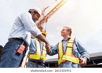 Engineer, Join hands, Team of engineer construction at site. Group of male engineer construction handshake together at construction site. Unity, cooperation and teamwork concept