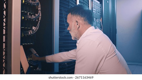 Engineer, laptop and cable connection at data center for network test, troubleshooting or solution. Mature person, inspection or technology in server room for firewall installation or hardware update