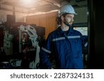 Engineer looking at screen and programming about performance of robotic arm,Researching and Developing a Technological Robot Arm Project. 