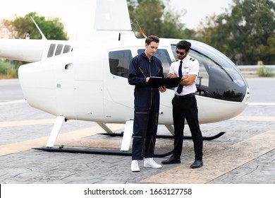 Engineer maintaining a helicopter Engine. Male pilot and machanic helicopter checking helicopter before take off