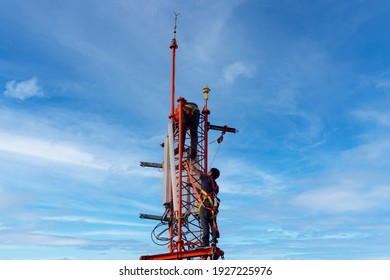Engineer maintenance on telecommunication tower doing ordinary maintenance and control to antenna for communication, 3G, 4G and 5G cellular. Cell Site Base Station on blu sky background.