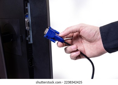 IT engineer Man hand inserts cable into monitor. Man hand connecting the DVI cable for monitor to computer PC. VGA DVI DisplayPort and power cable. close up in the hands of an . copy space.