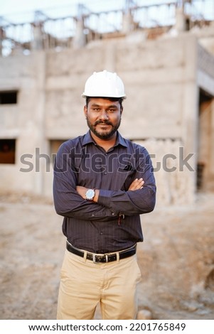 Engineer man hands holding hardhat white work helmet hard hat for Civil Construction Engineering. Construction engineer man in safety suit hold white work helmet hard hat on hands at Construction site