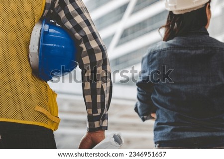 Engineer man hands holding hardhat white work helmet hard hat for Civil Construction Engineering. Construction engineer man in safety suit hold white work helmet hard hat on hands at Construction Site