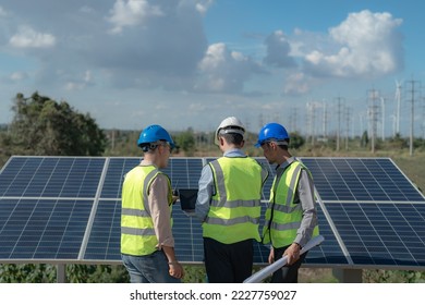 engineer man inspects construction of solar cell panel or photovoltaic cell by electronic device. Industrial Renewable energy of green power. factory worker working on tower roof. - Shutterstock ID 2227759027