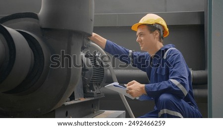 A Engineer man looking inspecting maintenance insulated pipelines valve pump control on the roof at an industrial site. He is wearing a hard hat and safety vest