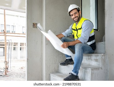 Engineer Man Reading Blueprint As Sitting At Home Improvement Construction Site. Professional Architect Wears Safety Hardhat Is Working On Home Interior, Housing Development Project. Copy Space.