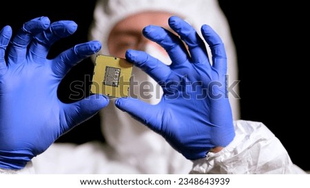 Engineer man in sterile suit is holding Microchip with symbols in modern design factory , futuristic and artificial intelligence concept