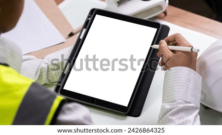 Engineer man using smart phone while standing at construction site. Over shoulder view, engineer use laptop computer typing code develop program  application on screen system app development concept.