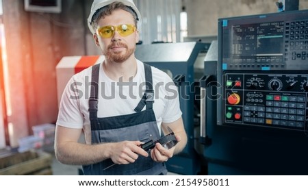 Engineer man work on CNC machine at automatic factory floor. Concept modern industry process metal detail production.