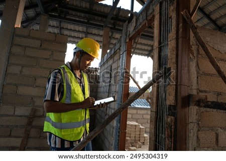 Engineer man working with tablet computer on construction site interior new house building