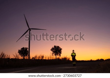 Engineer man working with tablet at windmill farm Generating electricity clean energy. Wind turbine farm generator by alternative green energy.