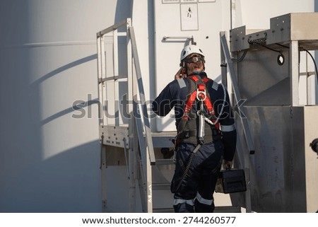 Engineer man working with tablet at windmill farm Generating electricity clean energy. Wind turbine farm generator by alternative green energy.