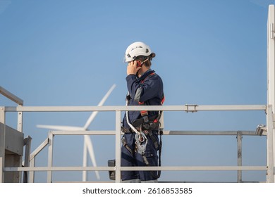 Engineer man working at windmill farm Generating electricity clean energy. Wind turbine farm generator by alternative green energy.