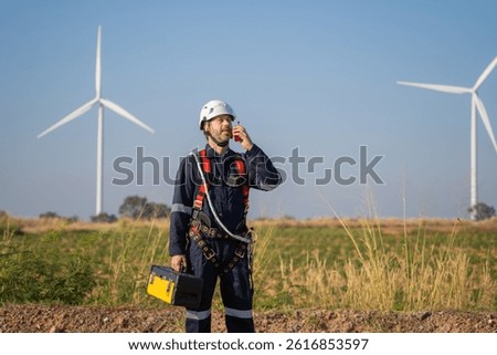 Engineer man working at windmill farm Generating electricity clean energy. Wind turbine farm generator by alternative green energy.