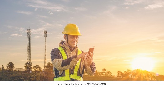 Engineer Manager Worker Speaking On Mobile Phone With Telecommunication Antenna And Sunset Background.