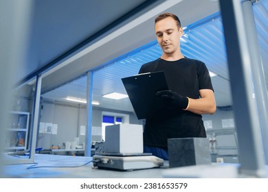 Engineer measures size and controls quality of concrete cube in laboratory. Concept industry lab for testing building materials. - Powered by Shutterstock