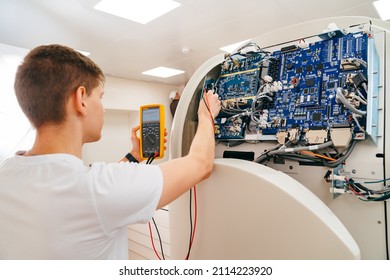 The Engineer Measures The Voltage In The Electrical Appliance. Repair And Adjustment Of Medical, Household Equipment. Professional Activity.