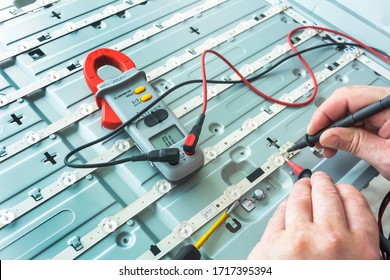 The Engineer Measures The Voltage On The LED Board With A Multimeter. Repair LED TV, Rear Panel Close-up.