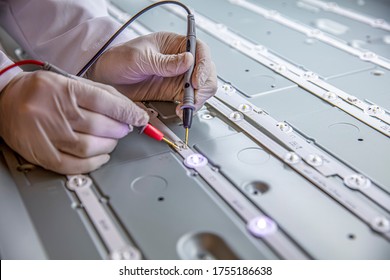 The Engineer Measures The Voltage On The LED Board With A Multimeter. Repair LED TV, Rear Panel Close-up.