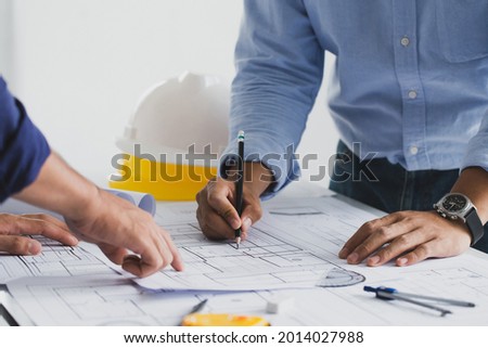 engineer meeting for an architectural project. working with partner and engineering tools working on blueprint architectural project at the construction site at desk in the office.