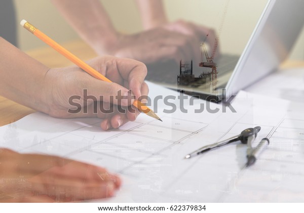 engineer\
meeting for architectural project, working with partner and\
engineering tools at workplace. Architect working on blueprint and\
laptop. double exposure with crane and building\
