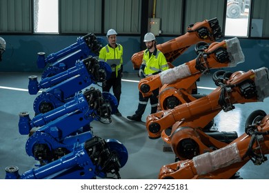 Engineer in modern industrial factory using laptop setting and inspect 
 robot arm controller in production plant factory.