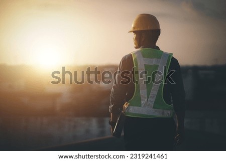 Engineer on a construction site at sunset. Working on the roof . 