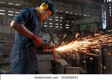 Engineer operating angle grinder hand tools in manufacturing factory - Mechanical engineering student using power tool with hot metal sparks wearing safety equipment - workshop and occupation concept - Shutterstock ID 1524246911