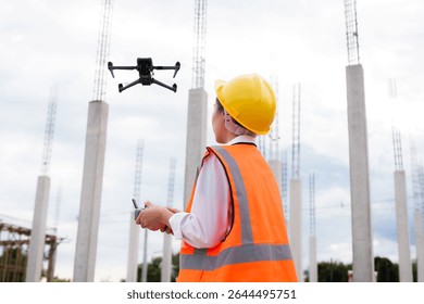 Engineer operating drone at construction site for industrial inspection and surveillance, ensuring safety, power infrastructure development, and environmental monitoring with advanced remote control t