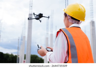 Engineer operating drone at construction site for industrial inspection and surveillance, ensuring safety, power infrastructure development, and environmental monitoring with advanced remote control t