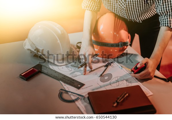 engineer people meeting working in office for
discussing, engineering .Hands of Engineer working on blueprint
Construction concept. Engineering
tools
